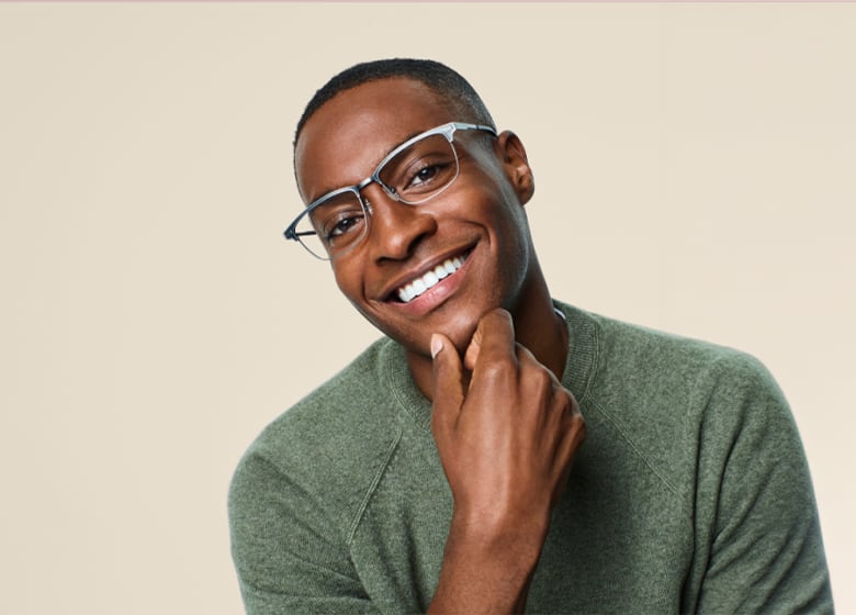 Man with a big smile wearing a pair of lightweight silver browline glasses.
